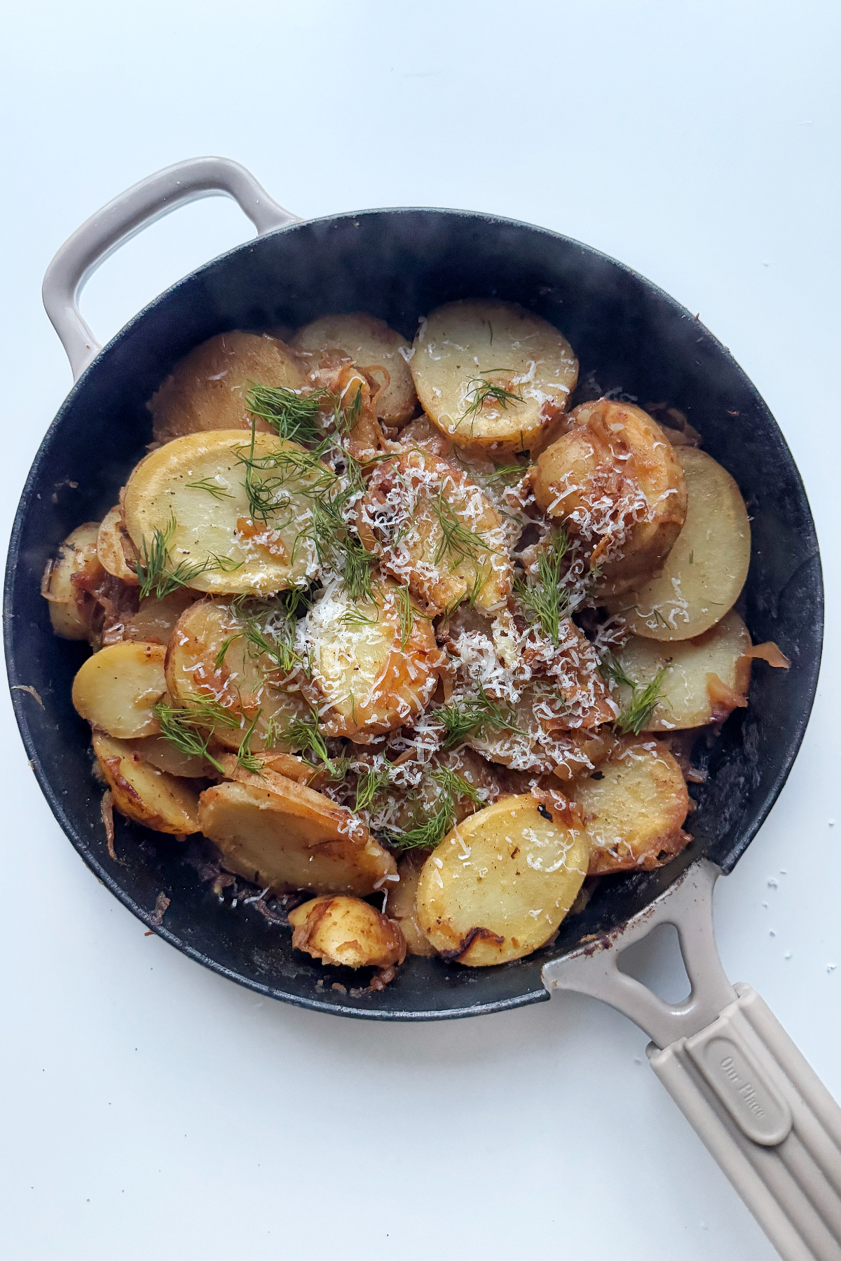 skillet fried potatoes and onions topped with parmesan and chives.