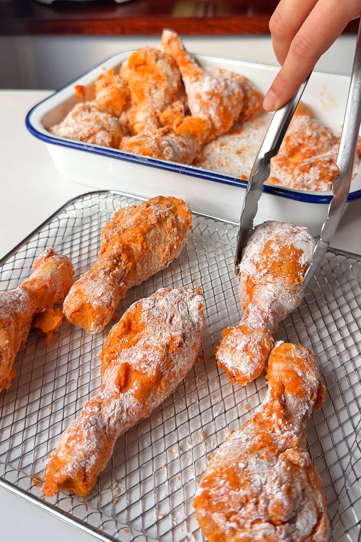 Placing chicken drumsticks on a wire rack.