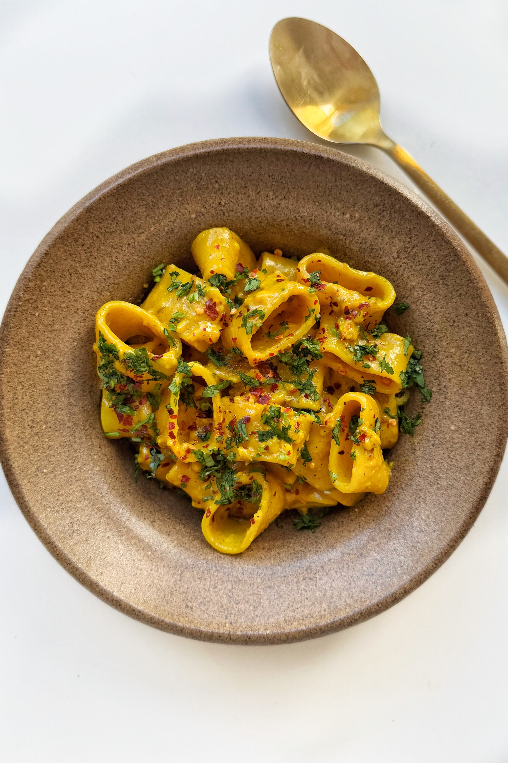 curry pasta in a brown bowl.