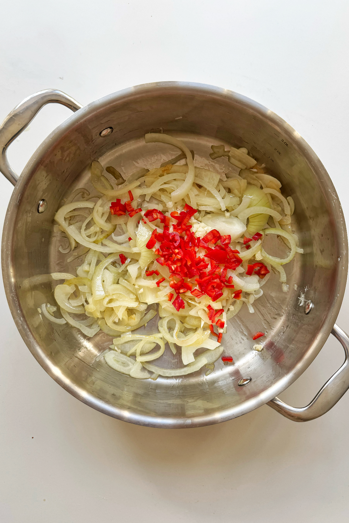 Frying garlic, onion, and chilli in a pan.