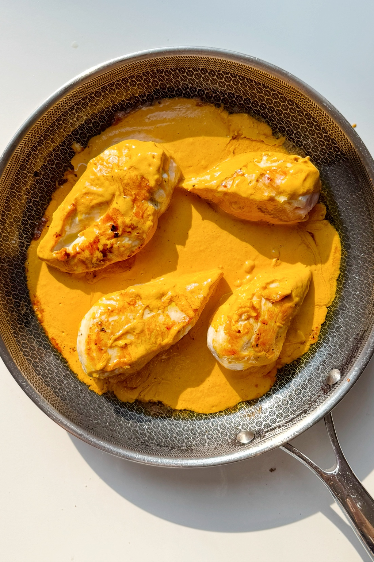 Cooking the chicken with the roasted red pepper sauce with lid on.