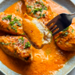 Close up of roasted red pepper chicken in a pan.