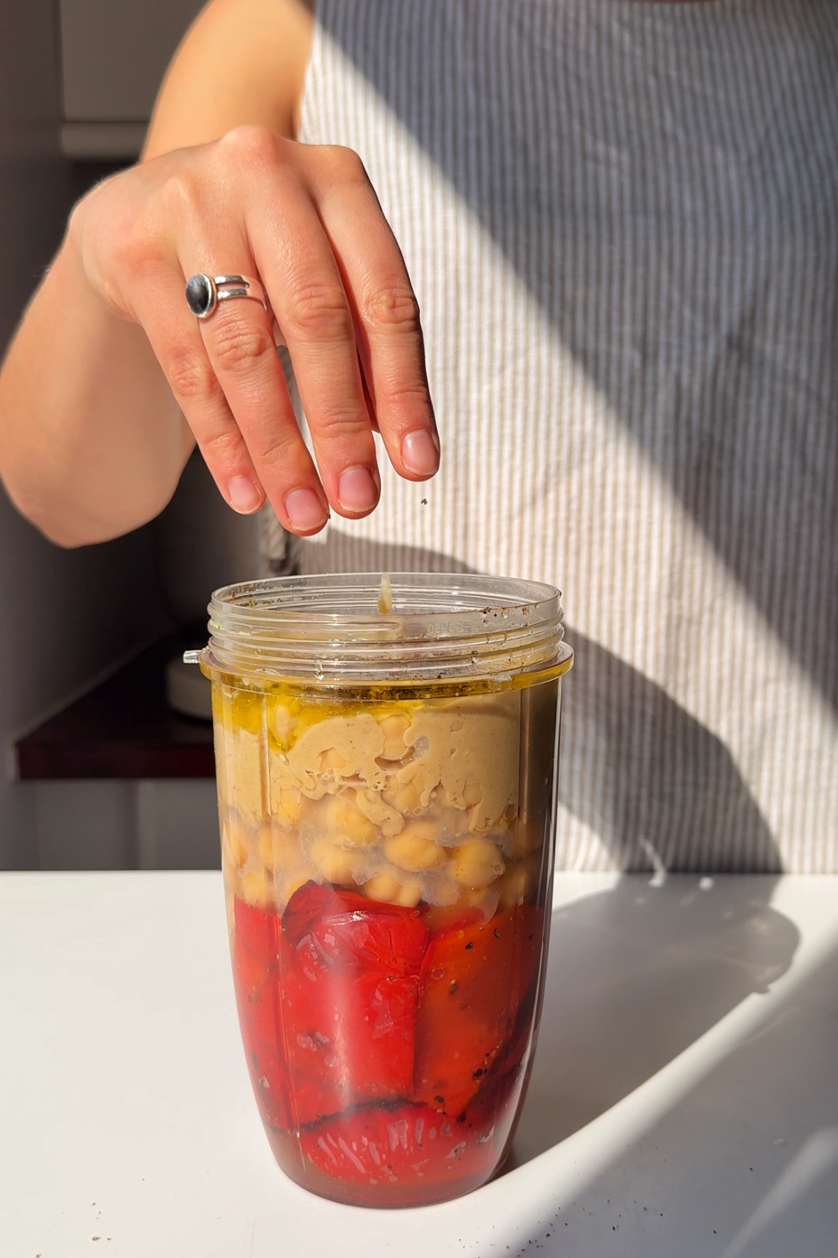Blending roasted red peppers with the other hummus ingredients.