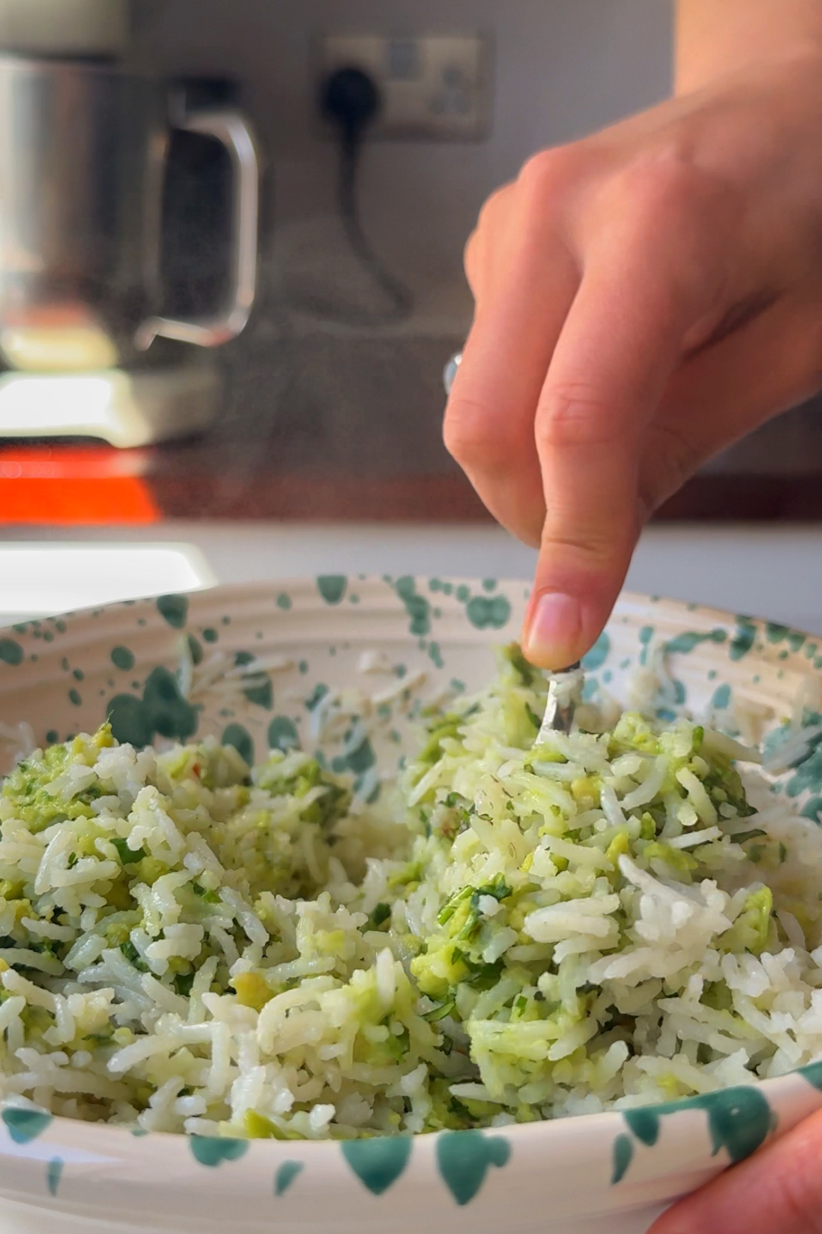 combining the avocado and the rice together.