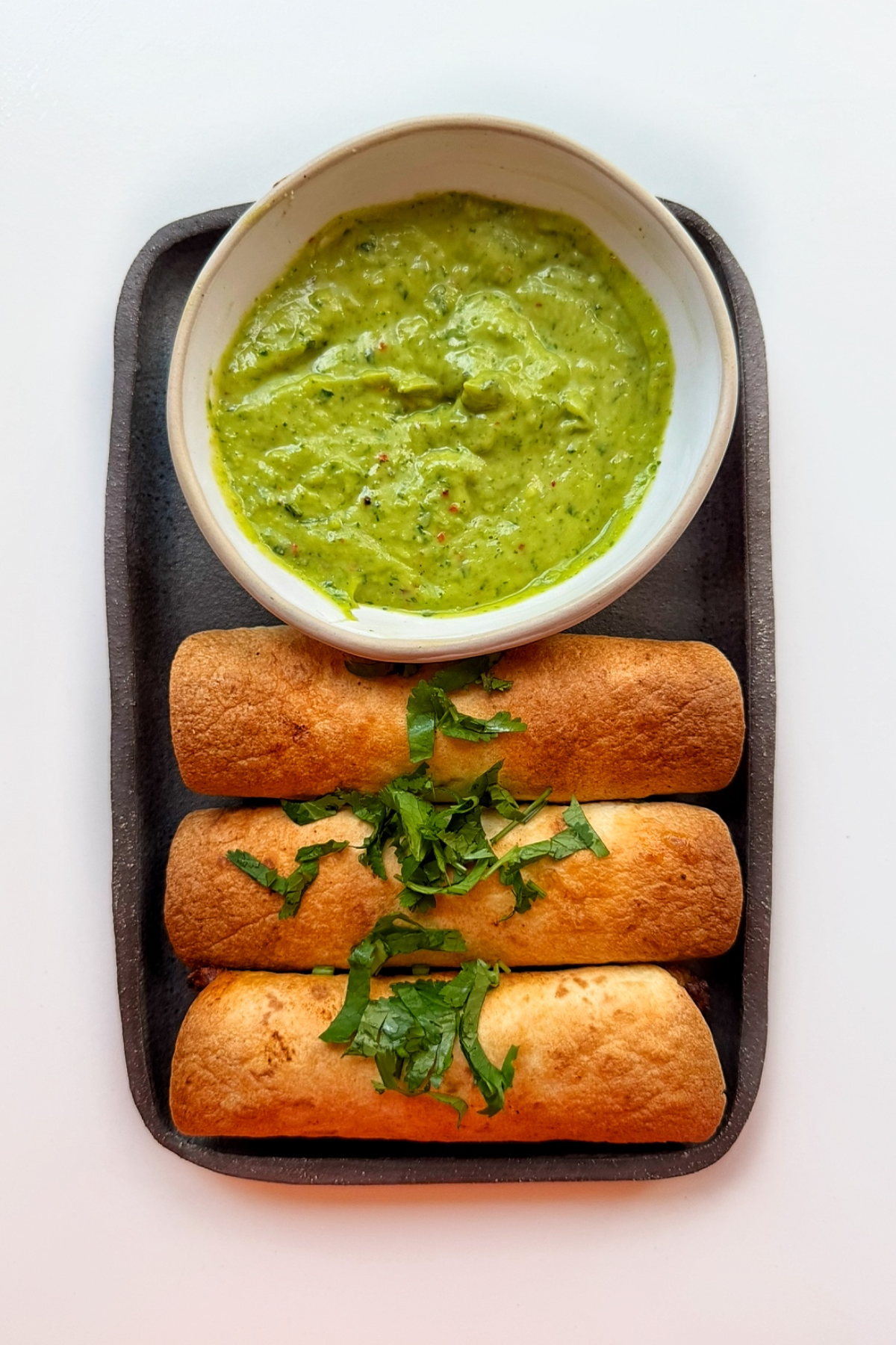 beef and cheese taquitos with an avocado sauce.
