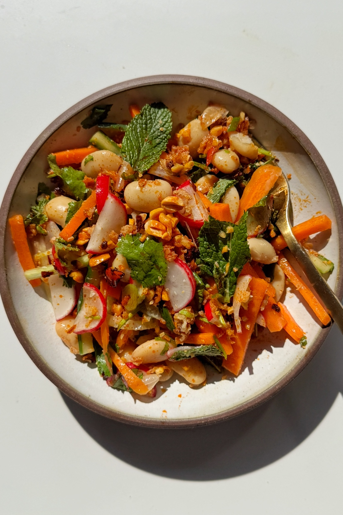 Butter bean salad in a bowl with a fork.