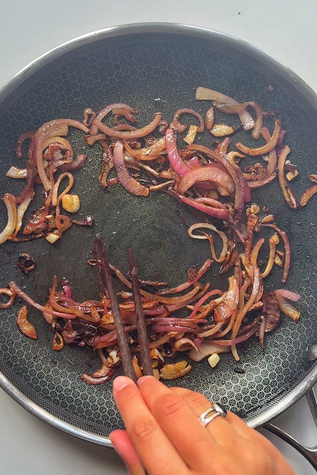 Frying onions until caramelised in pan.