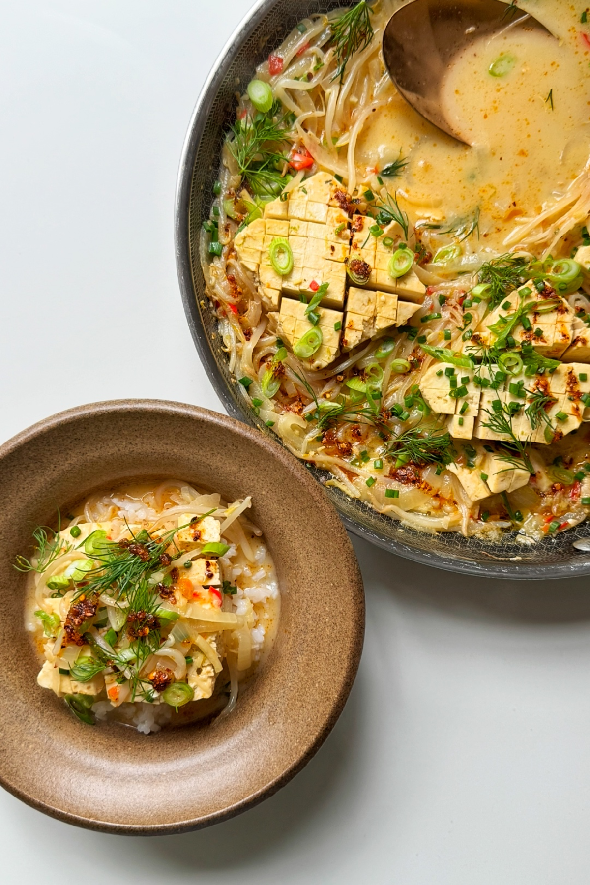 spicy coconut tofu in a bowl and black frying pan.