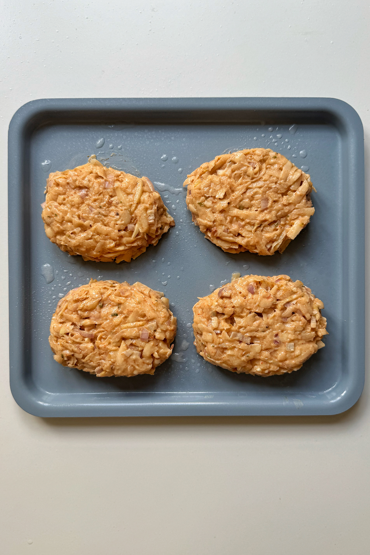 Formed hash browns on a tray to be cooked in the air fryer.
