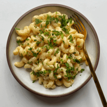 Tahini pasta in white bowl with fork.