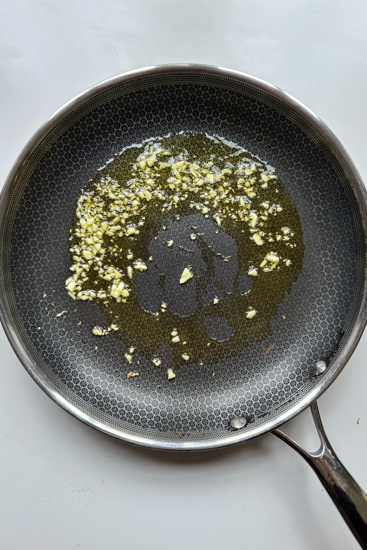 Frying garlic in a pan with olive oil.