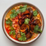 harissa rice with aubergine in a bowl on white surface.