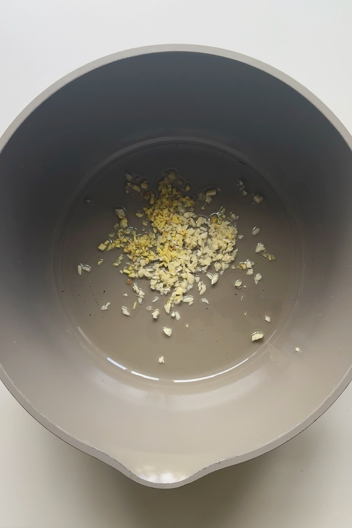 Frying garlic and ginger in pot.