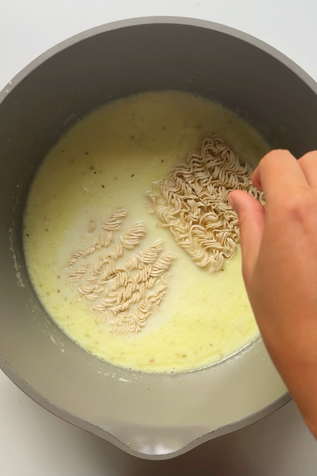 Noodles cooking in pan with coconut lime ramen.