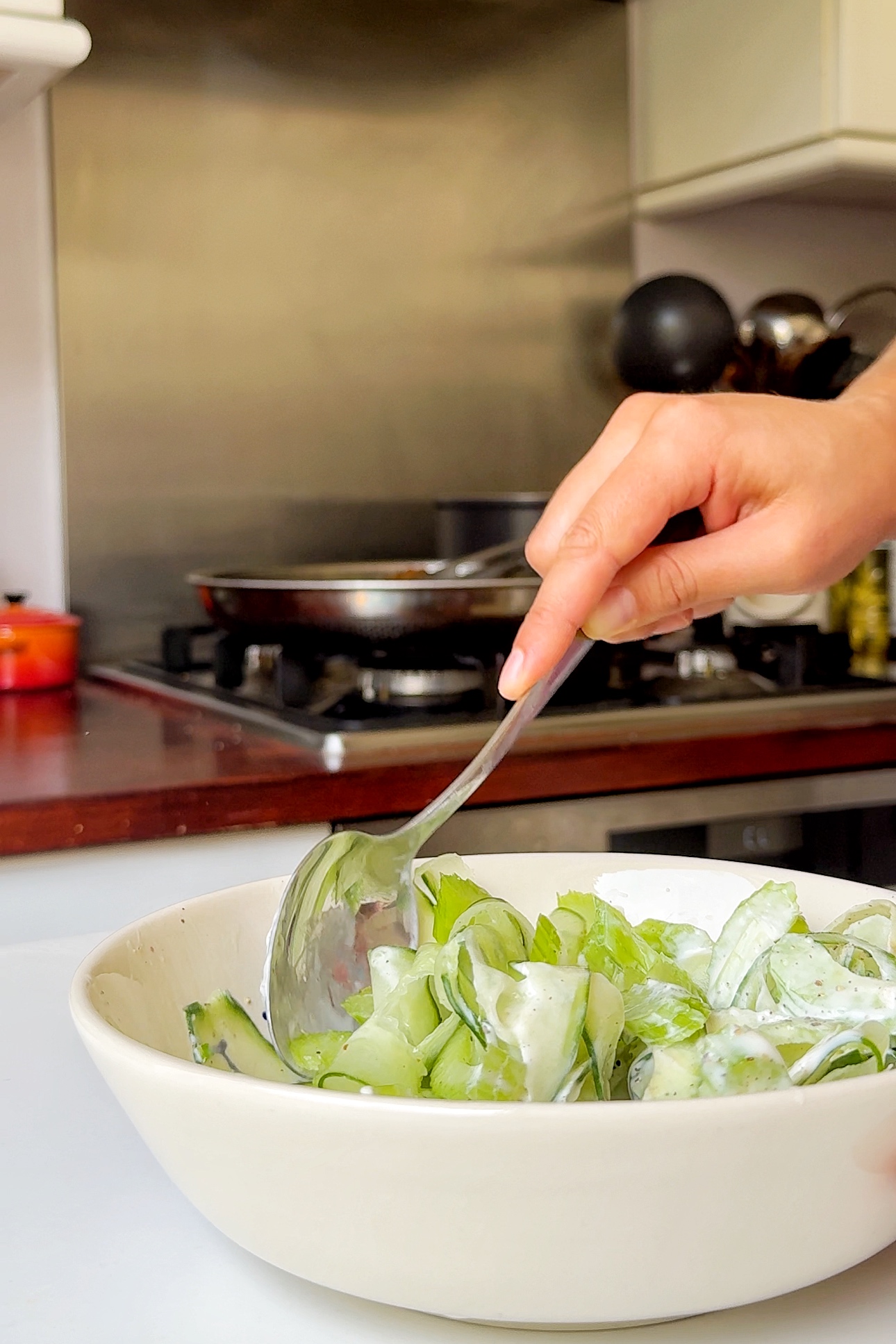 Making the cucumber celery slaw in a bowl.