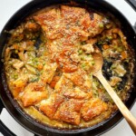 Black dish with chicken pot pie and a golden spoon.