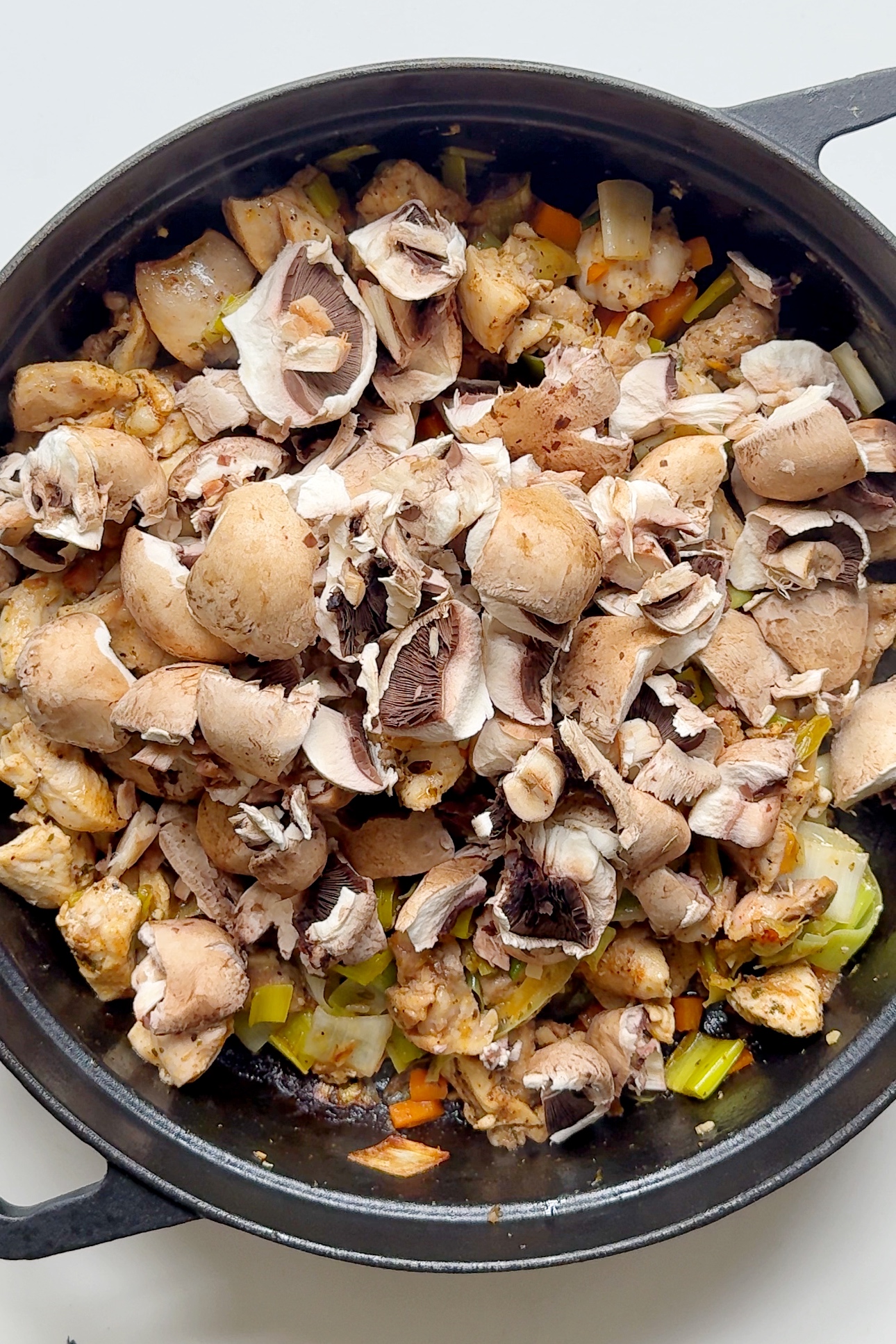 Frying chicken and mushrooms in the chicken pot pie pan.