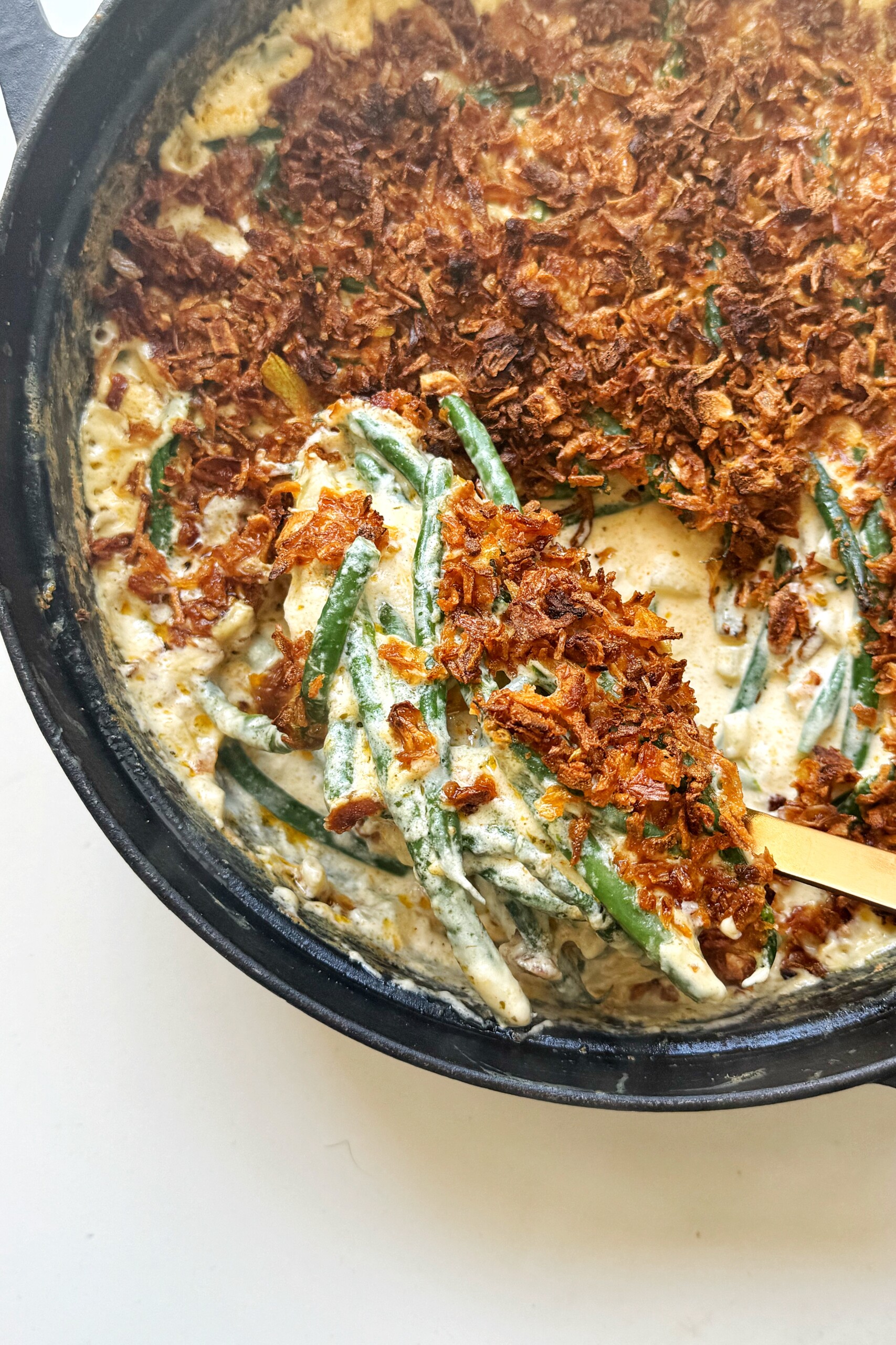 Spooning green bean casserole without mushroom.