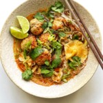 Bowl of noodle soup with chopsticks on the side of the bowl.