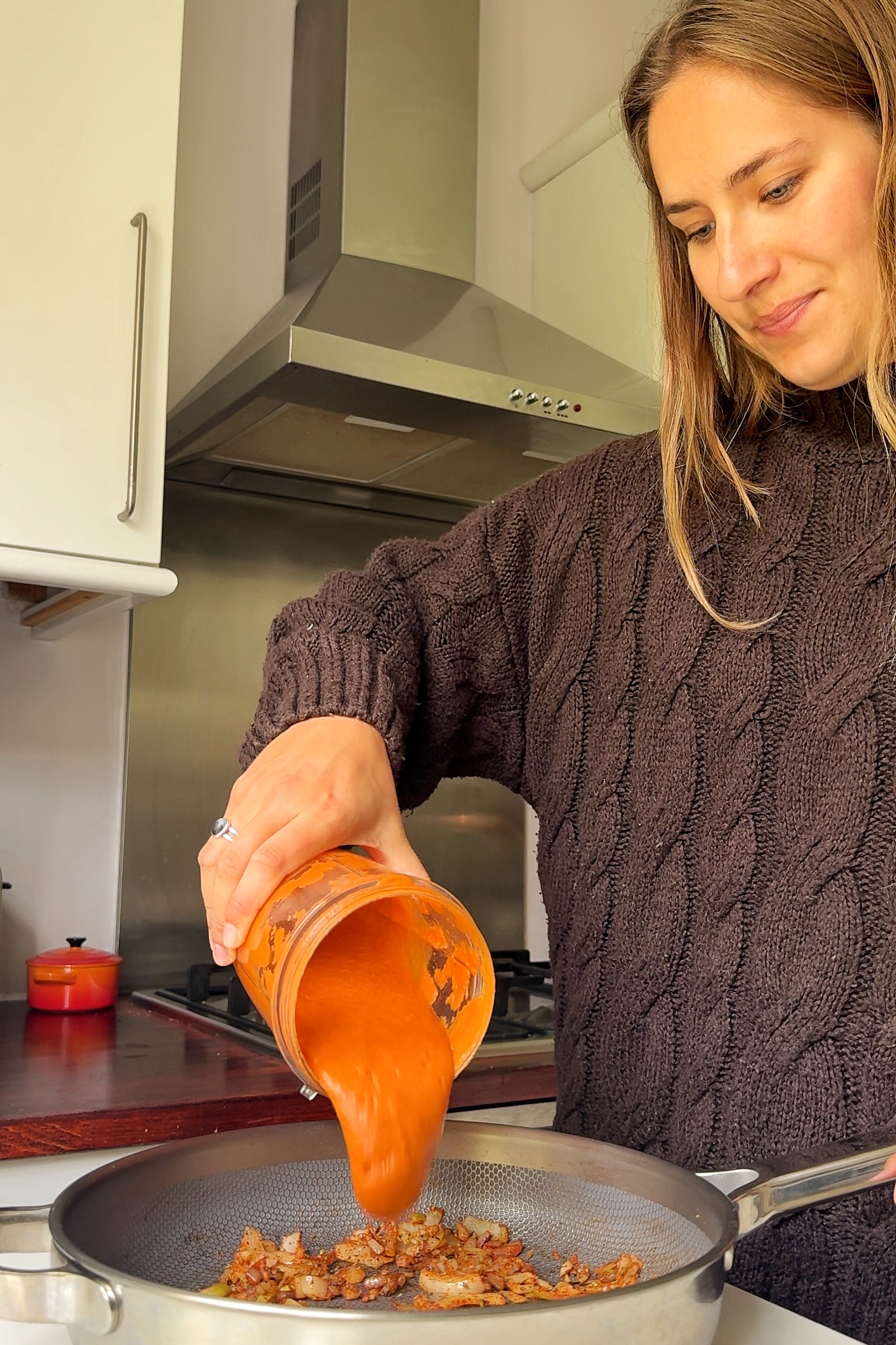 Pouring sauce into the pan.