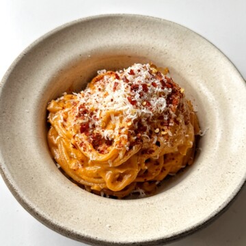 White bowl with sun-dried tomato pasta inside.