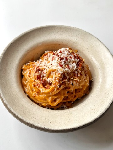 White bowl with sun-dried tomato pasta inside.