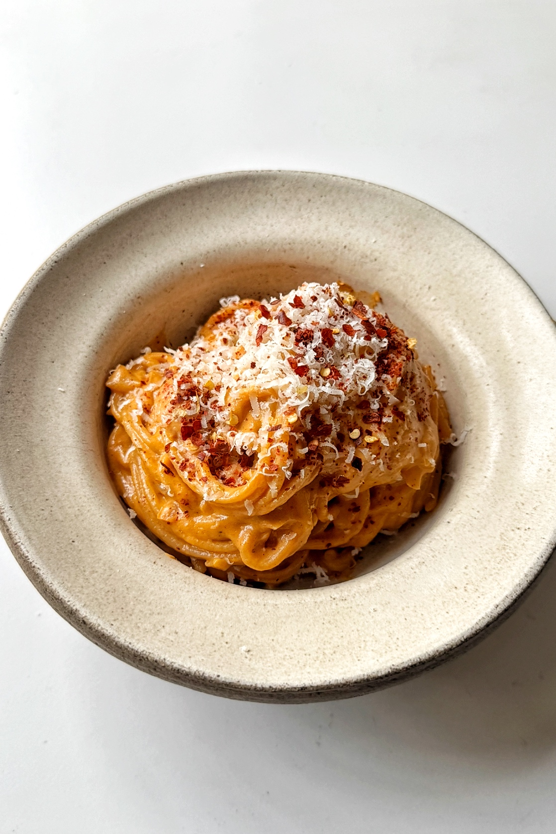 White bowl with sun-dried tomato pasta inside.
