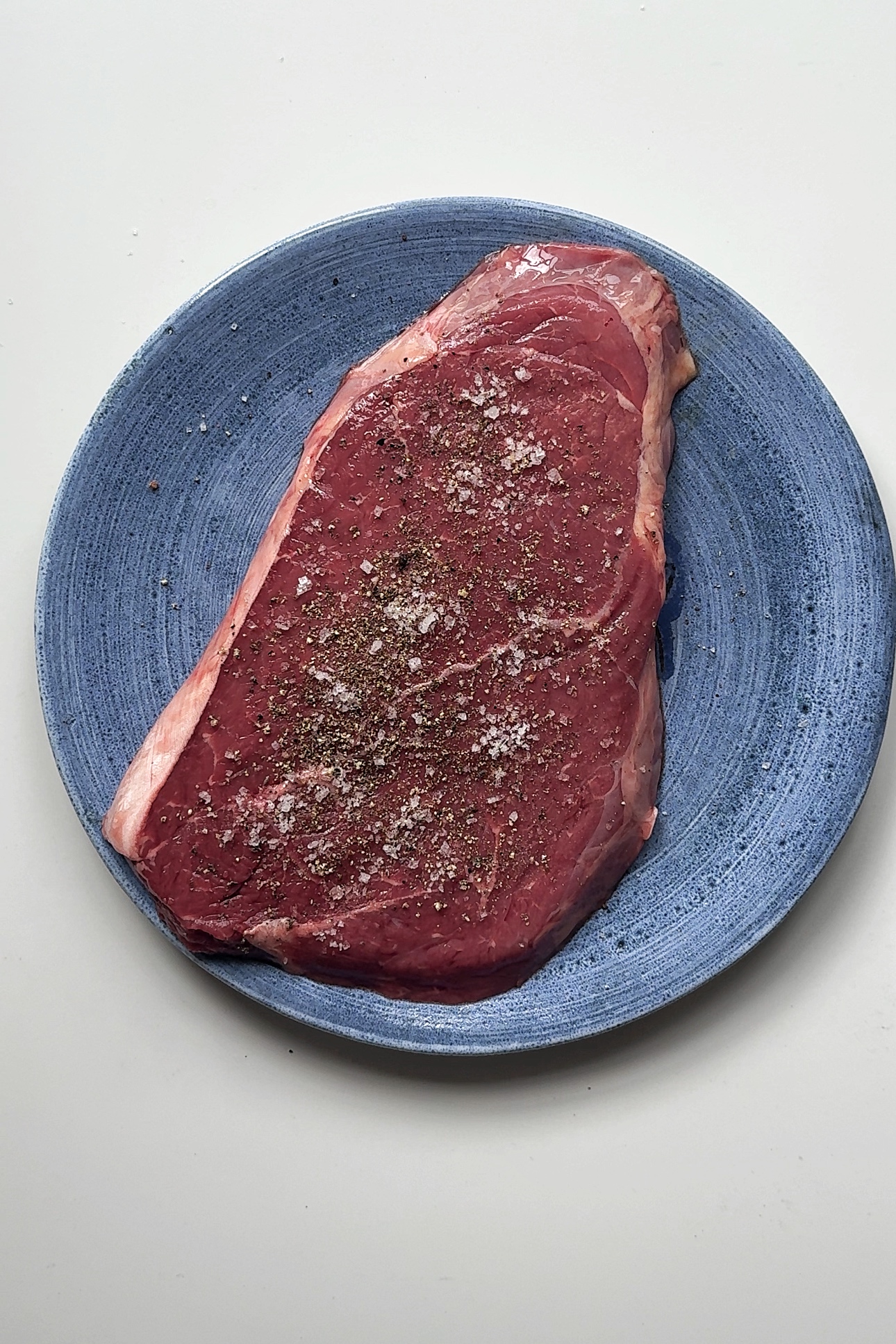 seasoning beef with salt and pepper.