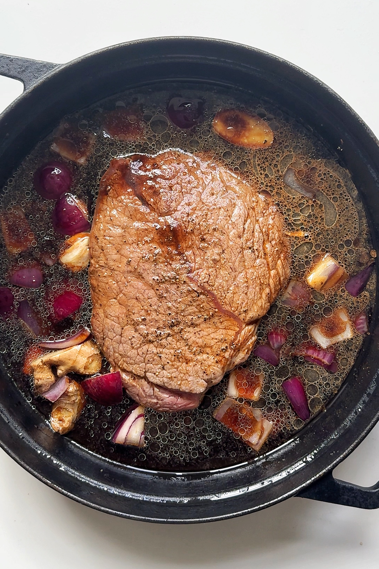 Slow cooking beef in pan.