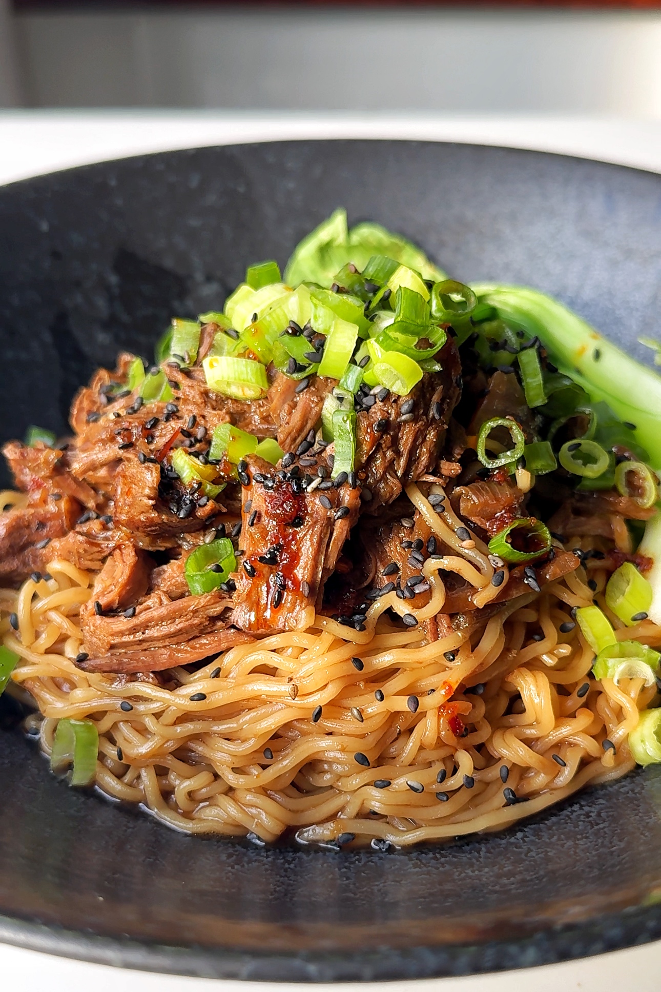 black ramen bowl with beef and ramen noodles.