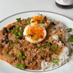 Bowl of spicy peanut butter ragu with jammy eggs.