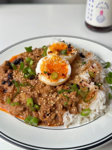 Bowl of spicy peanut butter ragu with jammy eggs.
