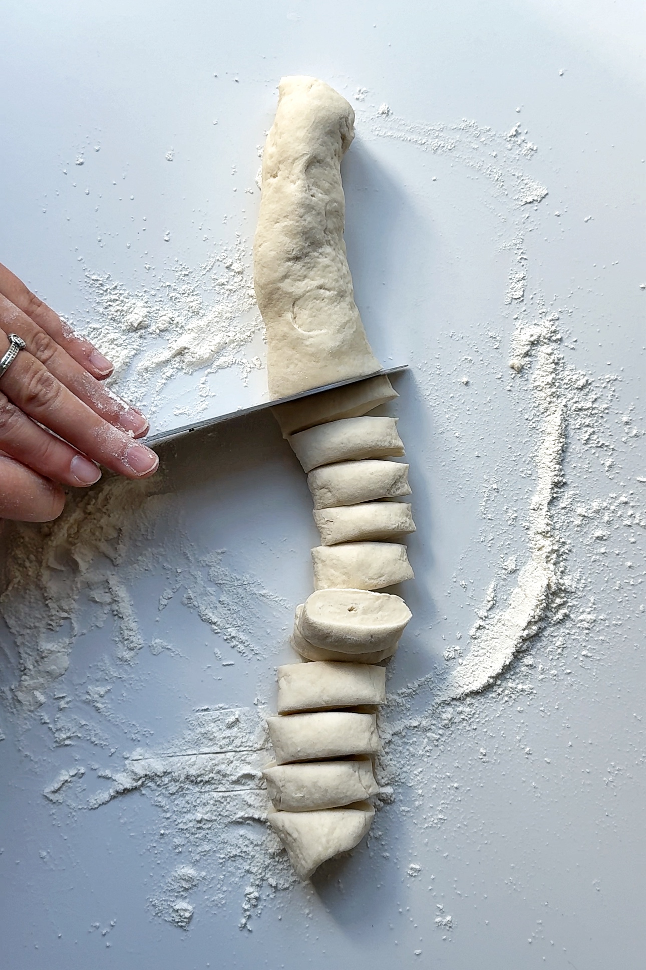slicing up dough to make momo wrappers.