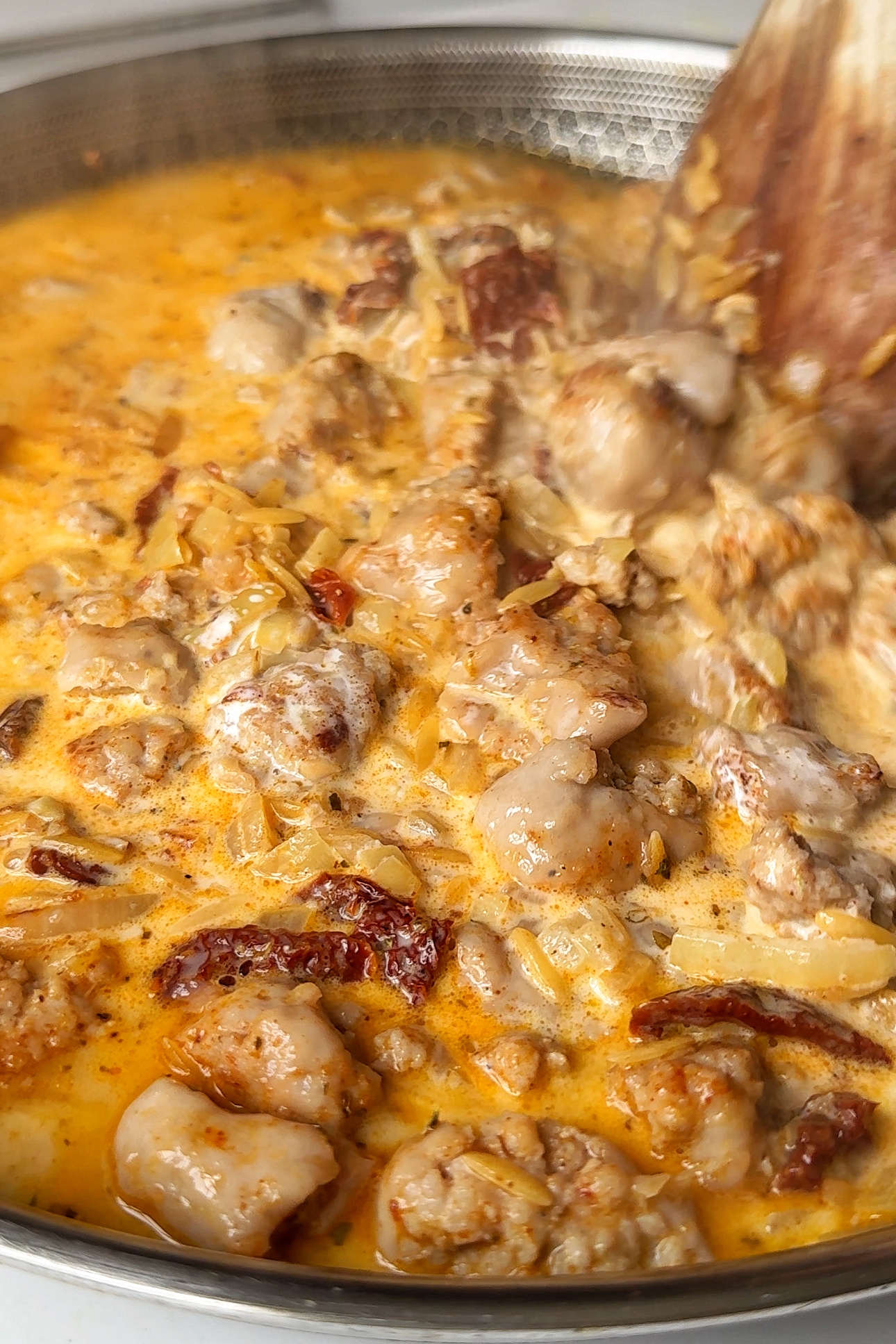 Cooking sausage orzotto.