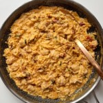 sausage orzotto in a black pan.
