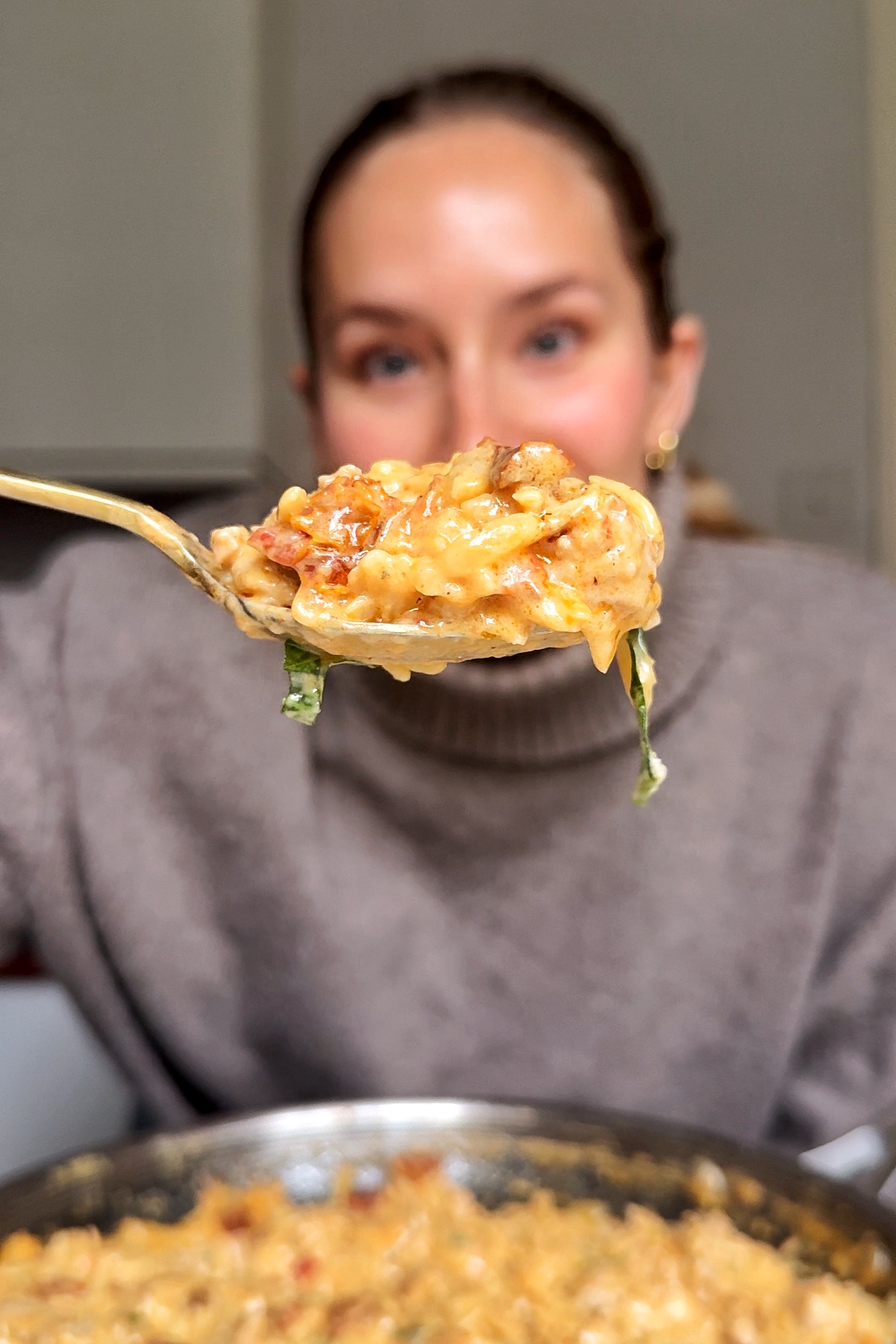 Emily Roz showing sausage orzotto to the camera.