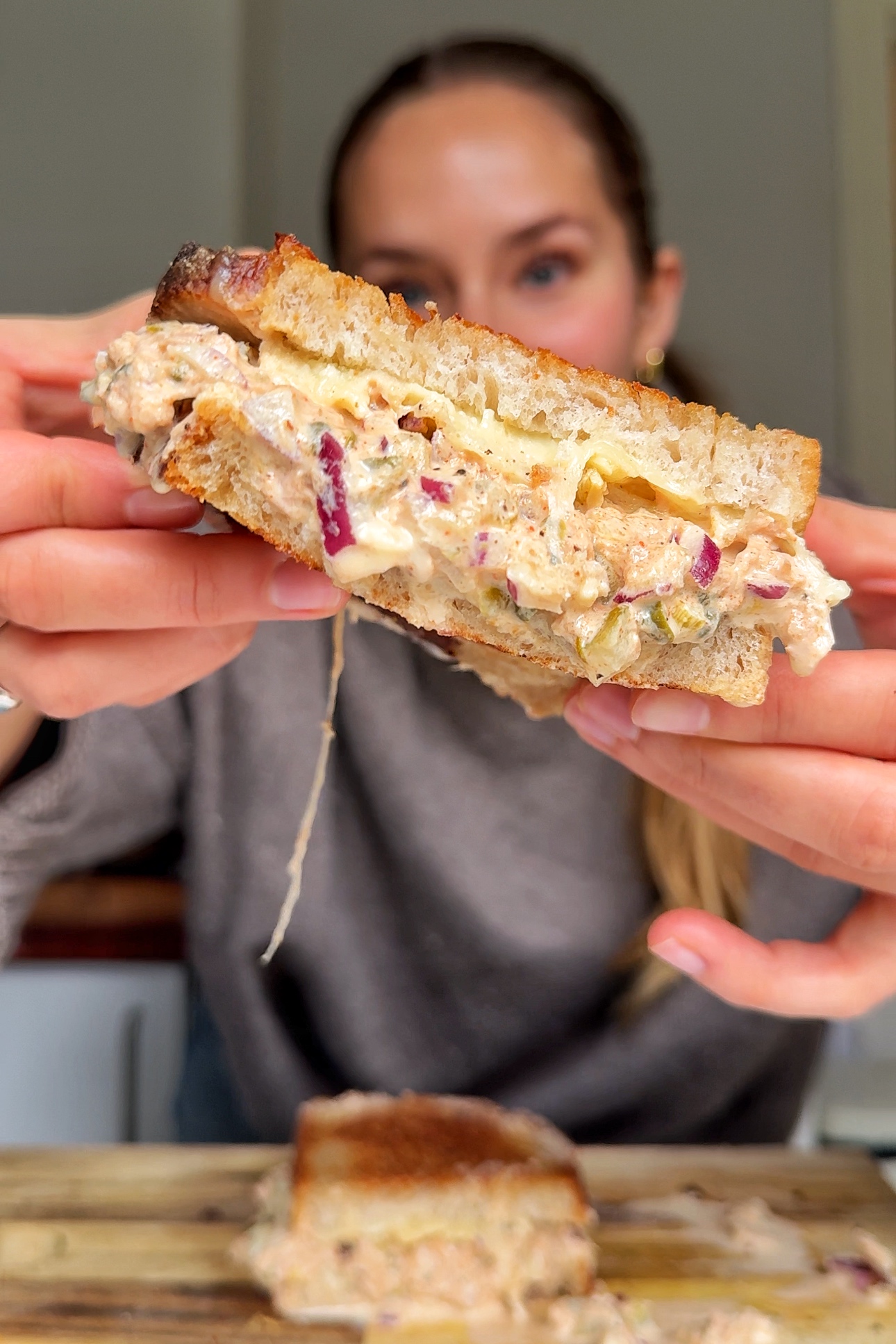 Emily showing the tuna melt to the camera.