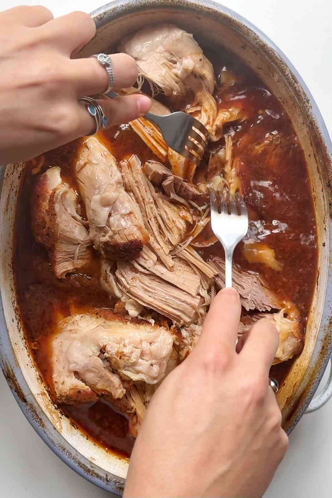 Tearing the pulled pork apart.