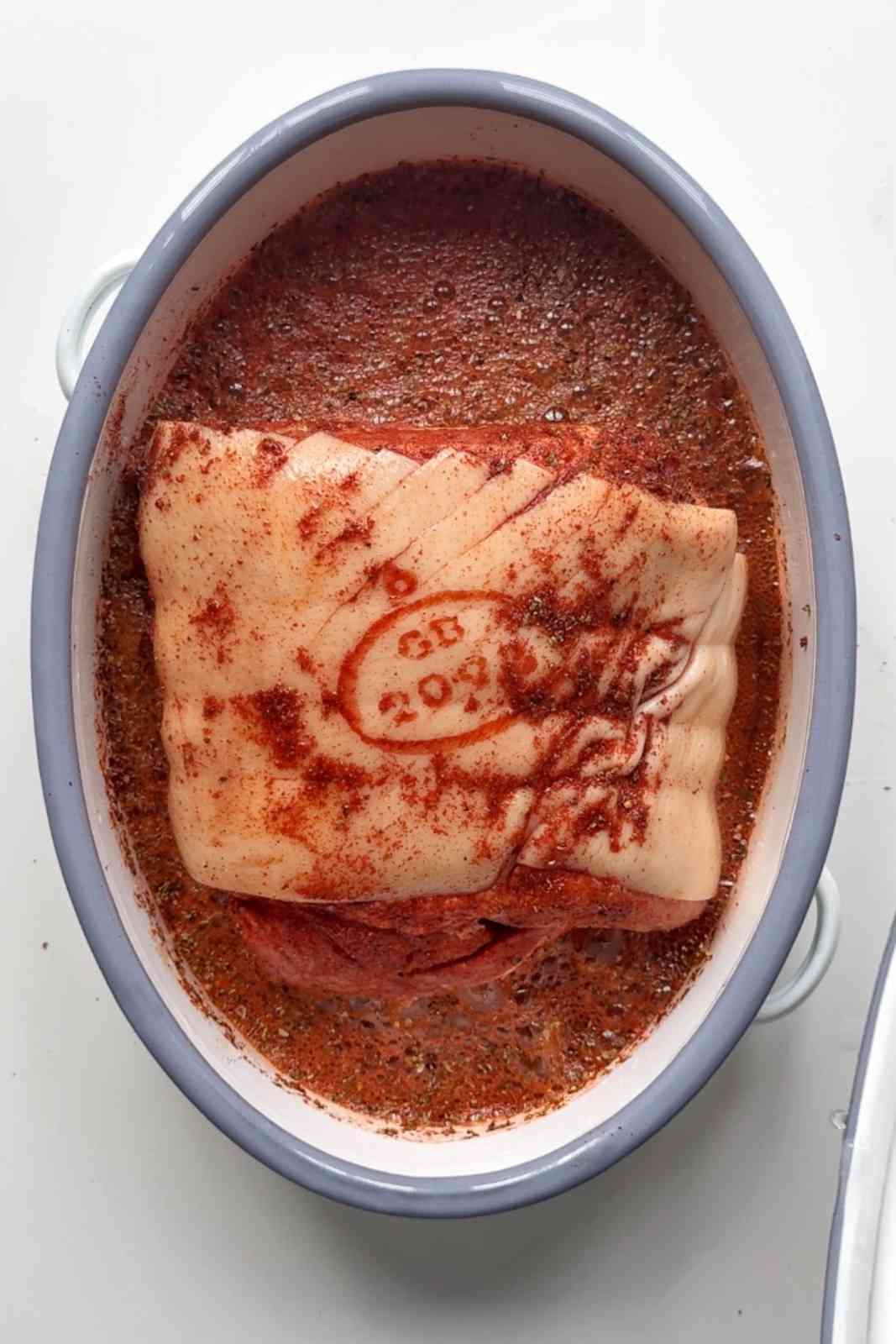 Adding cider into the pork joint.