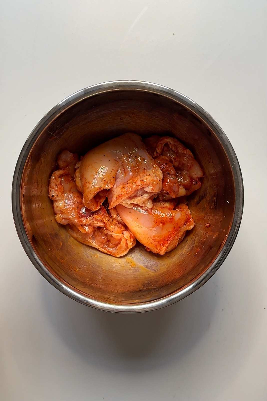 Marinating chicken thighs in bowl.