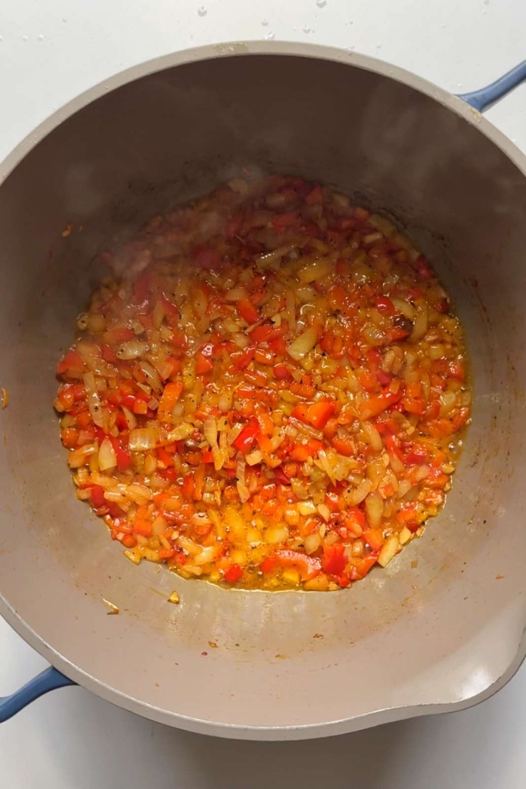 Frying off onions, garlic, and red pepper in a pot.