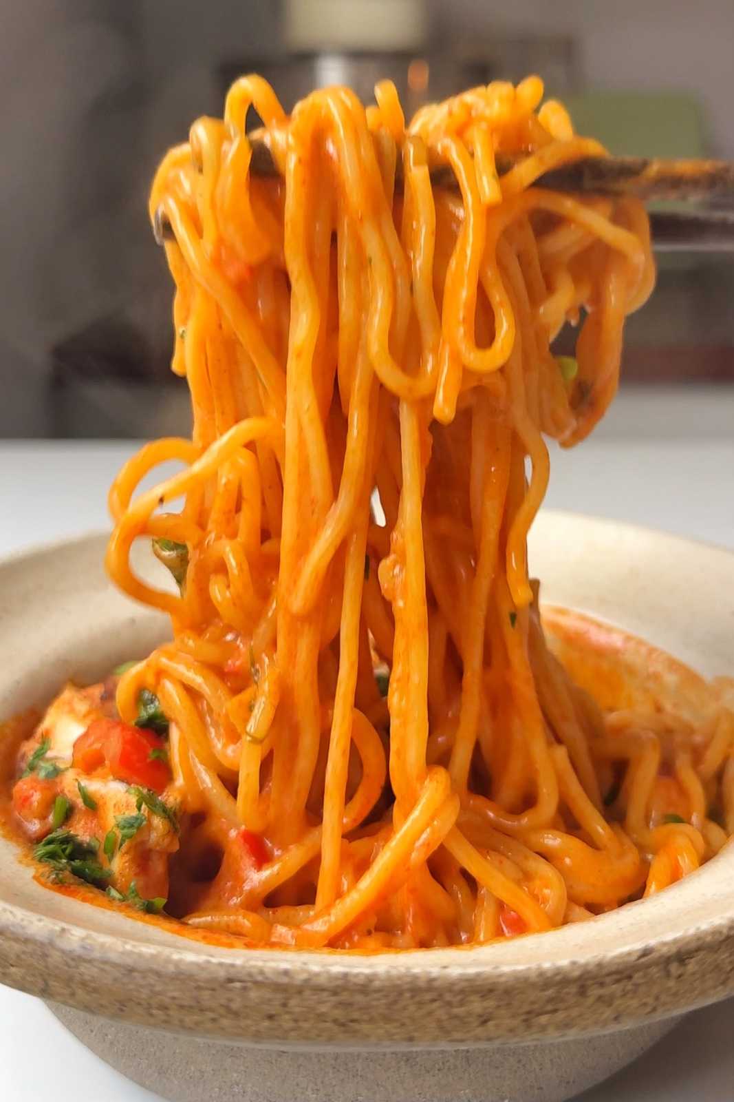 Noodle pull of chicken paprikash in white bowl.