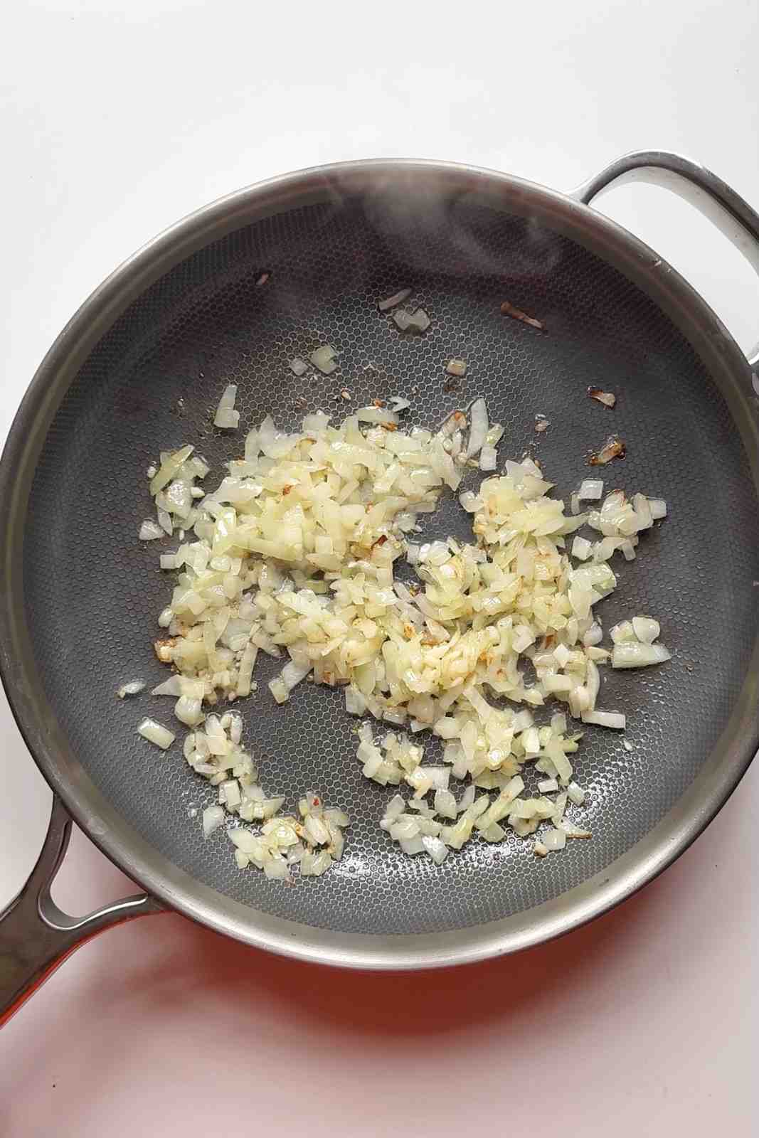 frying onion and garlic in a pan.