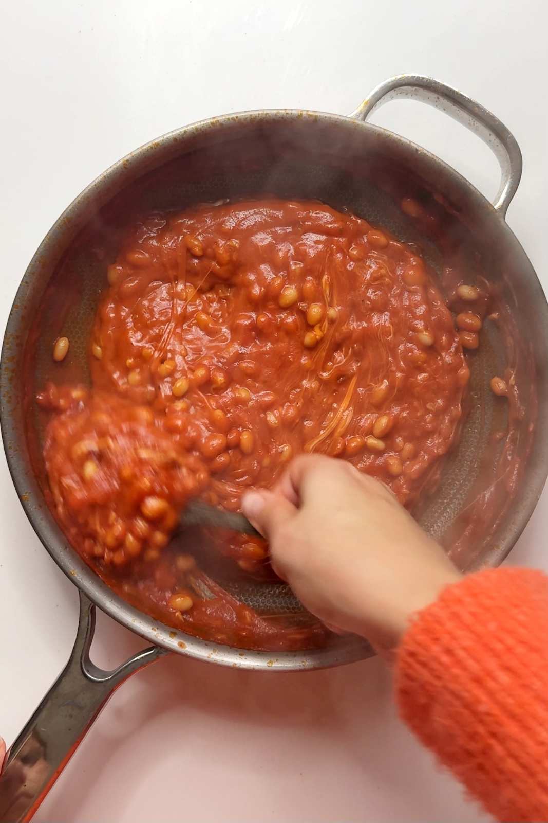 Adding cheese into the bean dish.