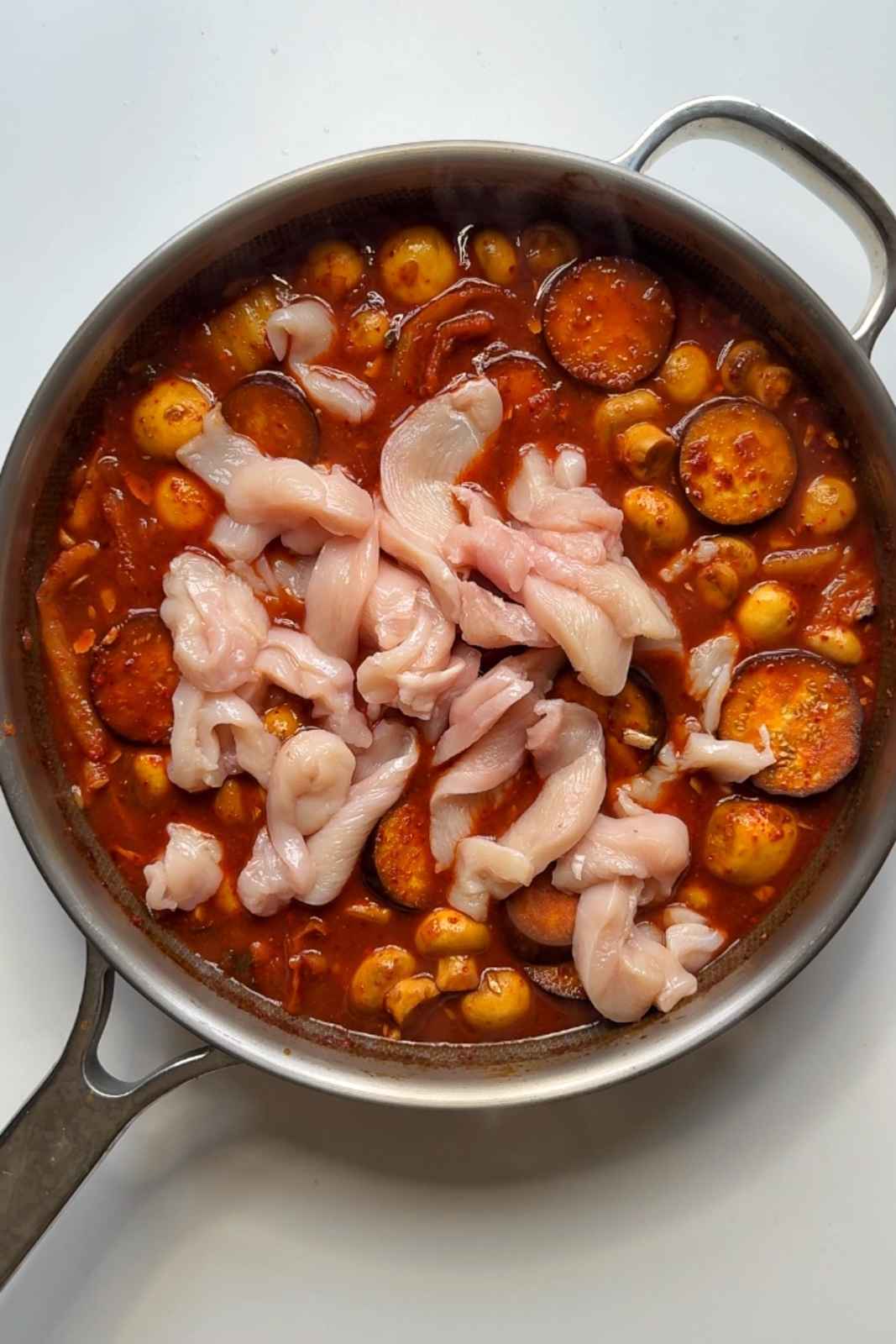 Adding chicken into the korean style stew.