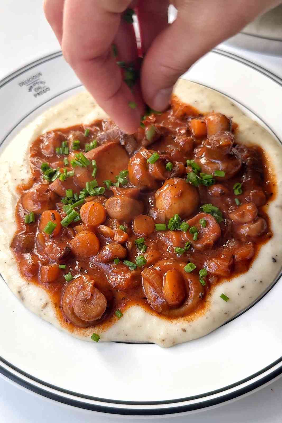 Topping mushroom bourguignon with chives.