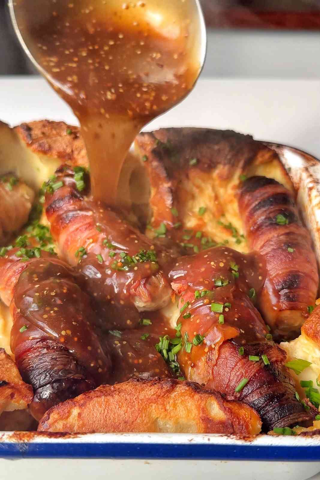 Pouring gravy over toad in the hole.