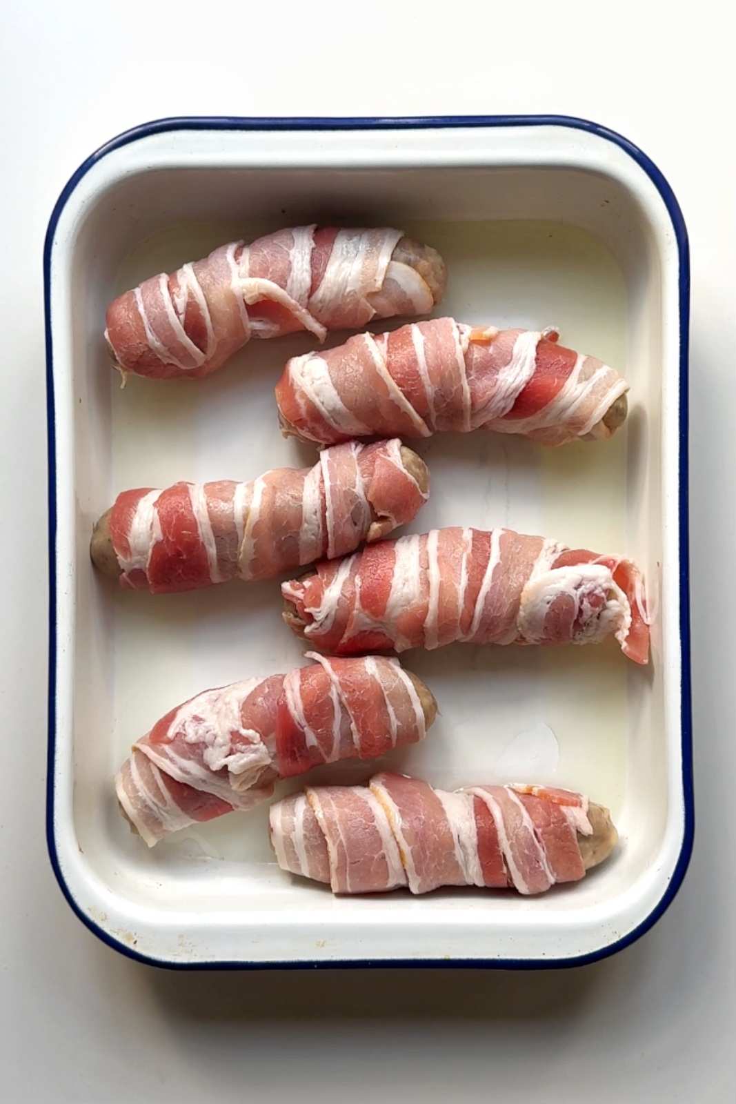 Placing pigs in blankets in tray.