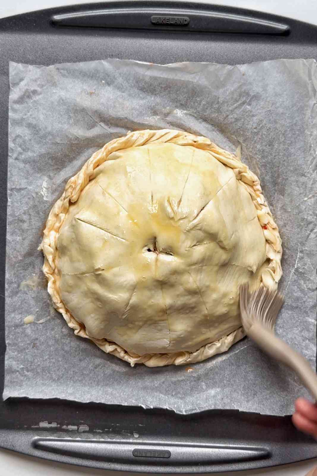 Brushing the pithivier with egg wash.