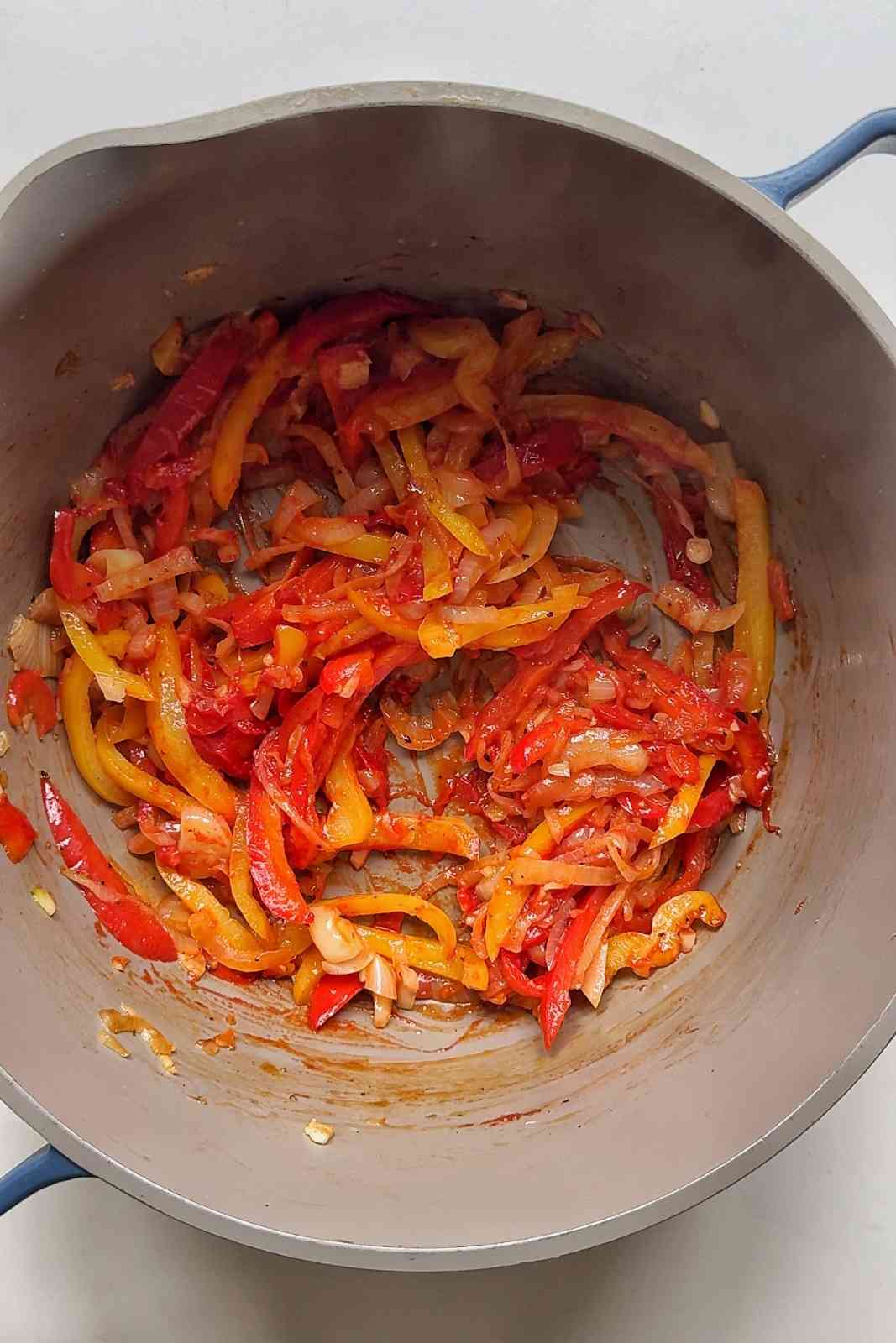 Frying off onions, garlic, and bell peppers in a pot.